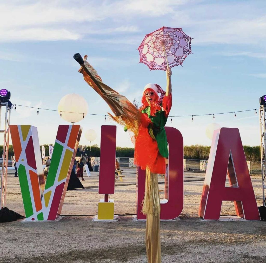 Dancer in front of the VIDA sign at Lights of Esperanza