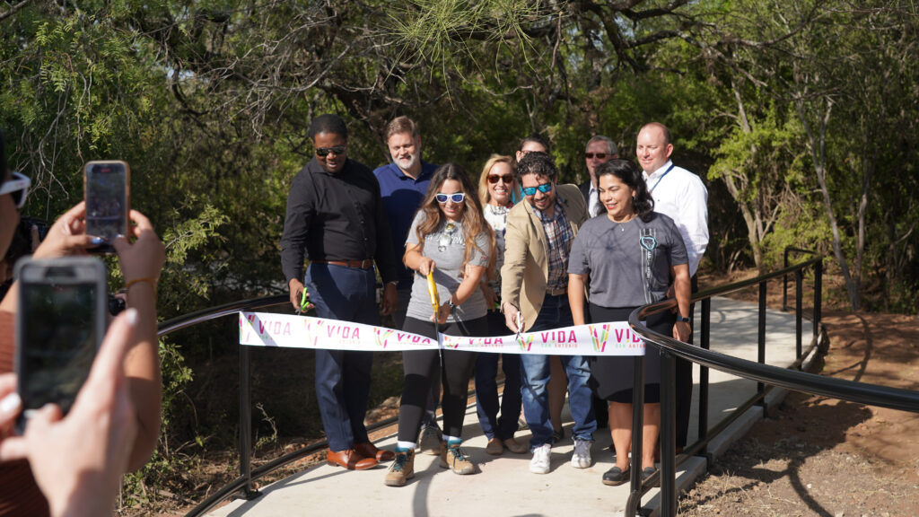 a group cutting a ribbon outdoors