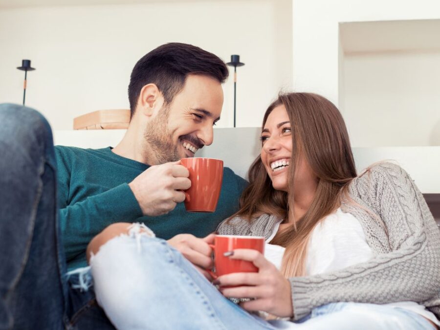 A couple relax into their couch at their new townhome at VIDA