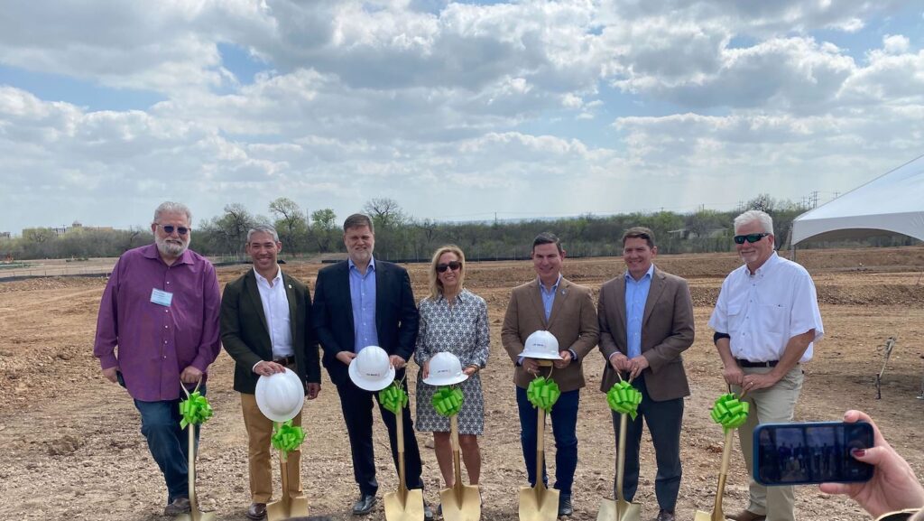 Mayor of San Antonio and Southstar leaders stand with golden shovels and construction hats at the site of the Los Arcos apartment complex groundbreaking. 