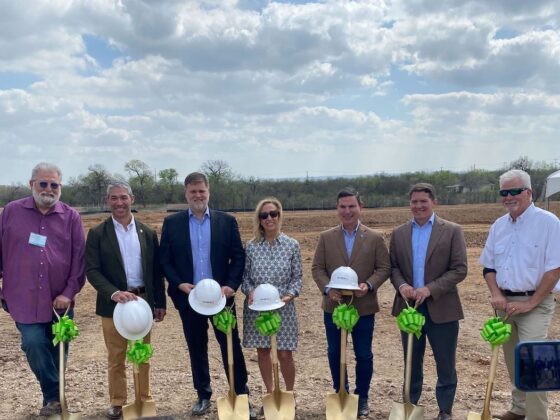 Mayor of San Antonio and Southstar leaders stand with golden shovels and construction hats at the site of the Los Arcos apartment complex groundbreaking.