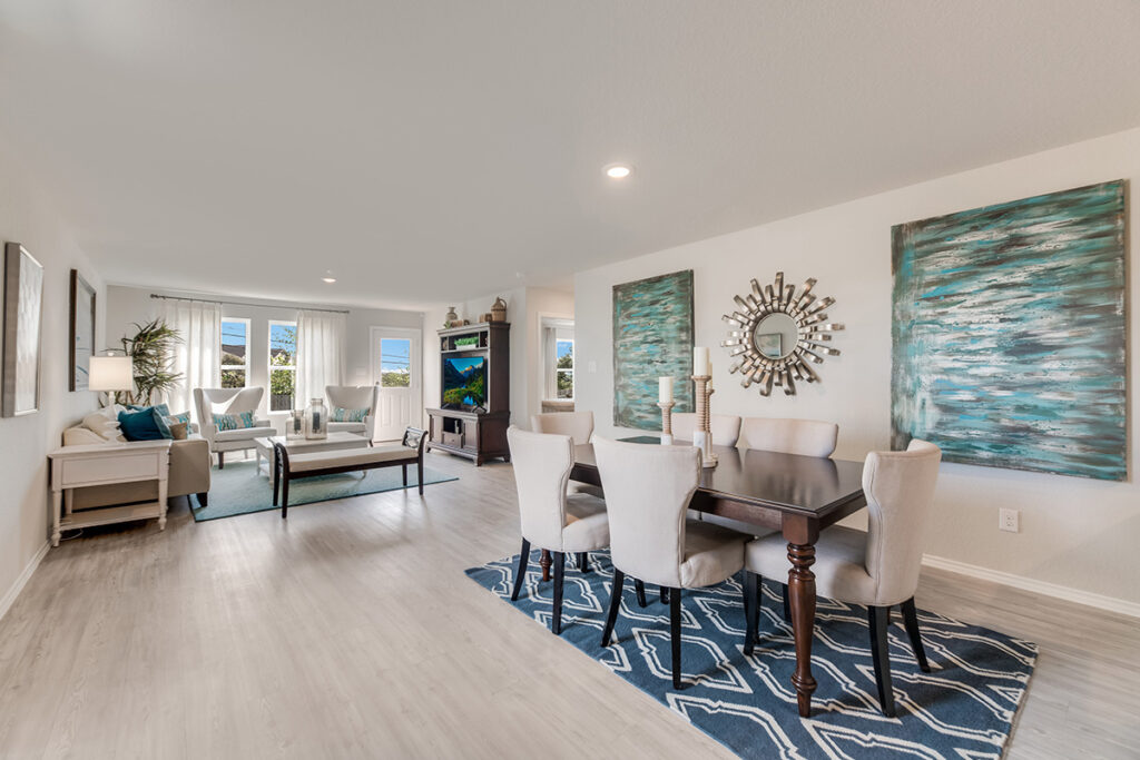 A wide angle view of a contemporary living room and dining room in a Lennar Home at VIDA San Antonio.