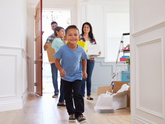 Portrait Of Hispanic Family Moving Into New Home