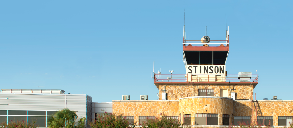 A high angle of the Stinson Airport building from a distance. A blue sky in the background.