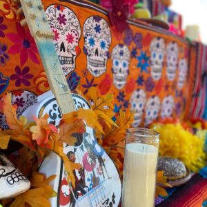 Candles and a guitar on an ofrenda