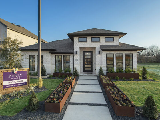 Perry Homes Model Home at VIDA, A Contemporary, Single Floor Model Home against a blue sky with green grass in the front yard