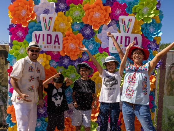 A Latino family cracks a cascarone and throws their arms up at Festival de Cascarones