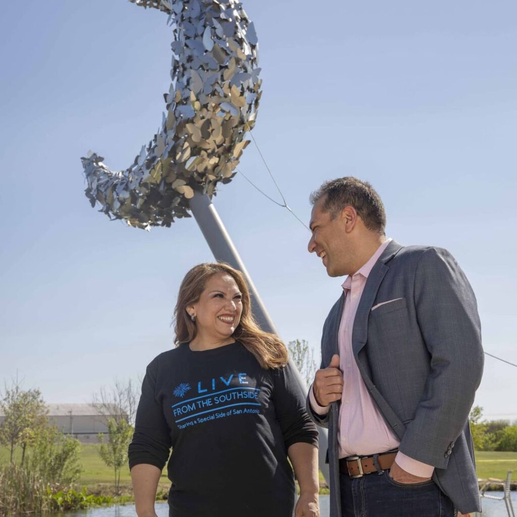 April Monterrosa smiles with a guest in front of a sculpture on the Southside