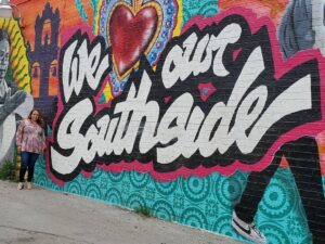 April Monterrosa poses in front of the "We Heart The Southside" mural in San Antonio