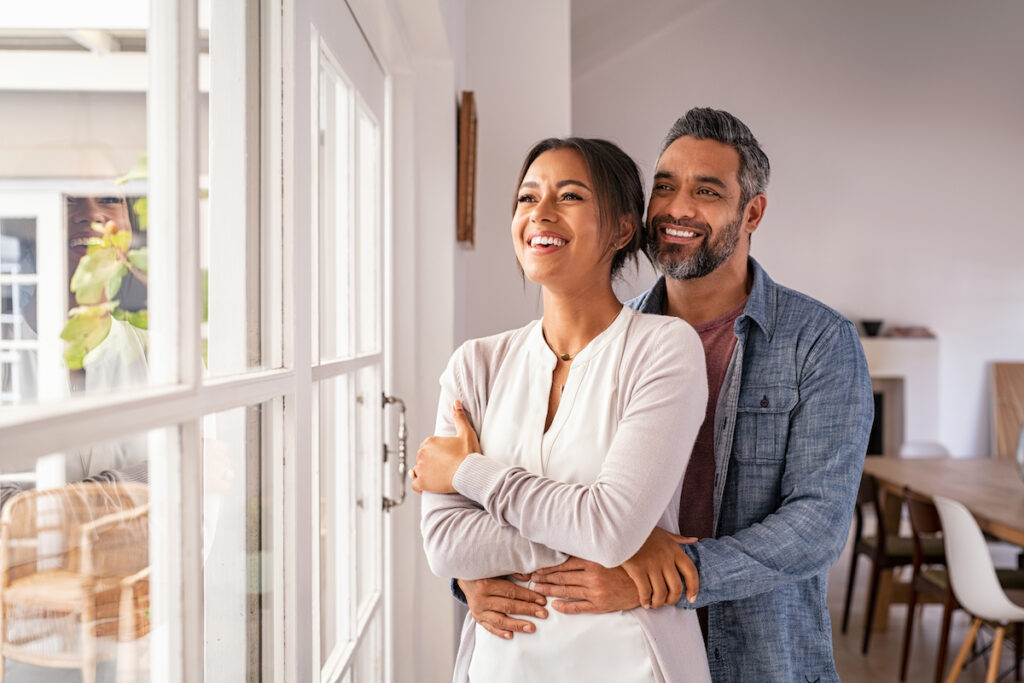 A couple looks out the window of their energy efficient home at VIDA San Antonio