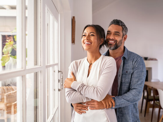 A couple looks out the window of their energy efficient home at VIDA San Antonio