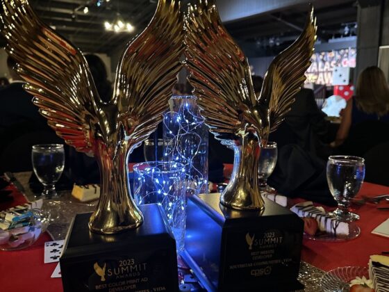 two gold and winged trophies sit atop a table dedicated to VIDA San Antonio