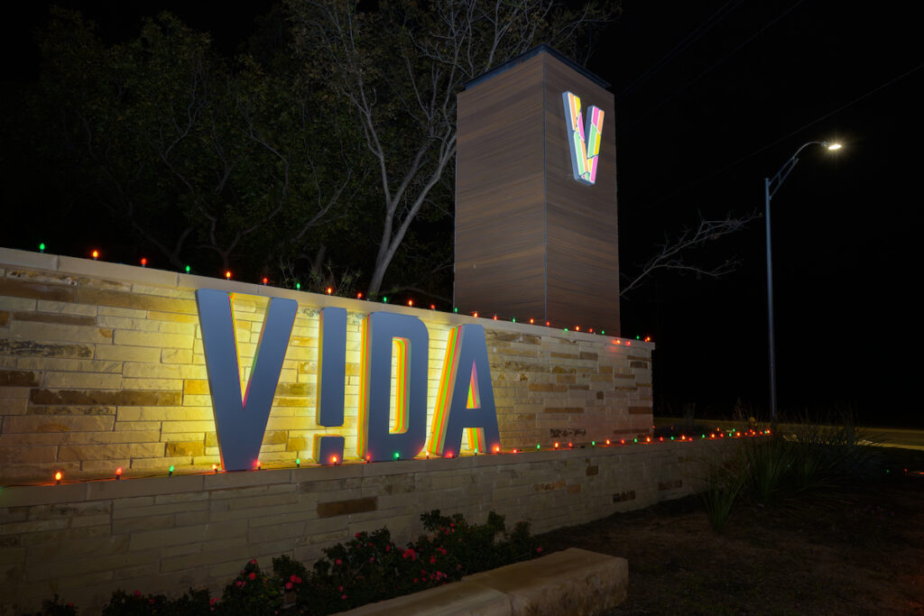 The VIDA sign lit with holiday lights at night