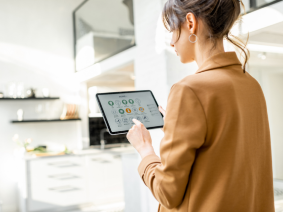 A woman uses a tablet to control features in her smart home.