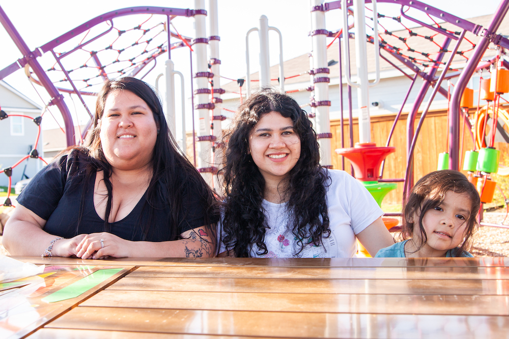 a family sits down in Ana Park at VIDA San Antonio