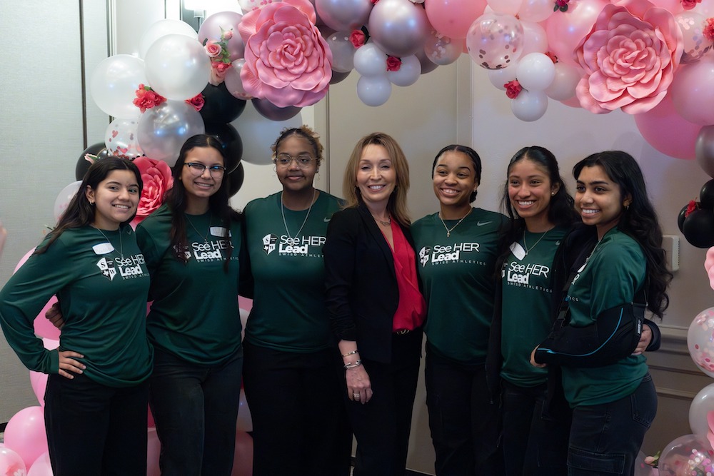 Jeanette Ball poses for a photo with a group of young women