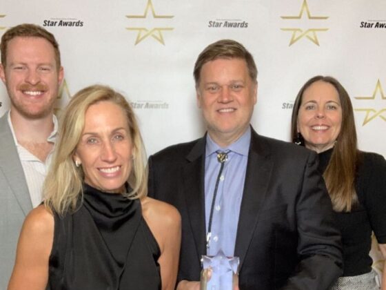 Staff from Developer Southstar smile while holding awards from an event.