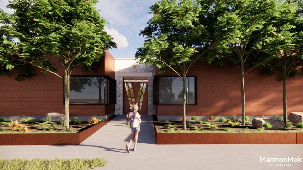 A person with a backpack walks towards the modern entrance of the community clubhouse, flanked by two trees. The clubhouse structure features large windows and red brick walls. A path lined with small plants and rocks leads to the nearby pool under a clear, sunny sky.