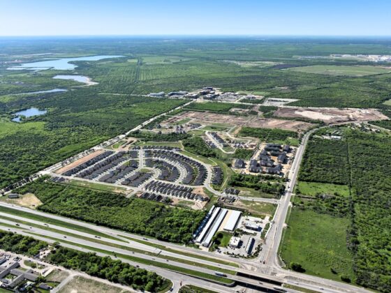 A sprawling aerial view of the lush landscape around VIDA San Antonio and the growing community.