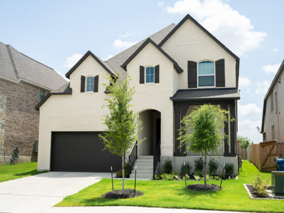 A beige brick home with black accents built by Perry Homes in the VIDA San Antonio neighborhood
