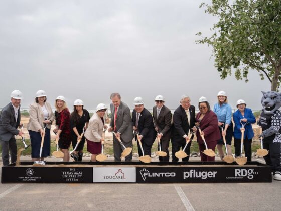 Educare stakeholders and sponsors come together for a groundbreaking. They hold shovels and stand near the Texas A&M - SA mascot.