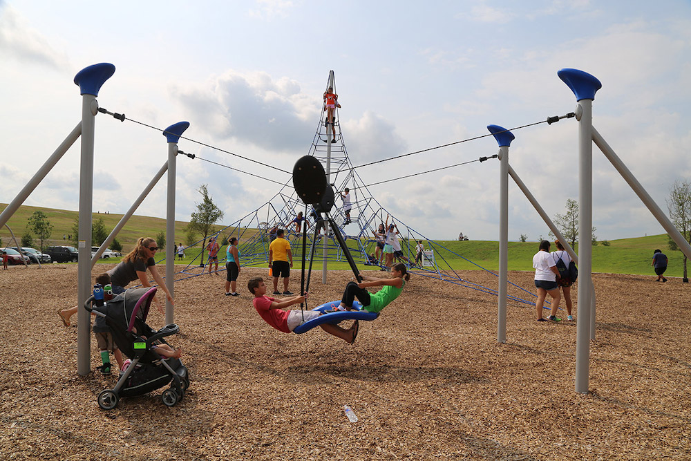 Children play outside on a zipline at Pearsall Park