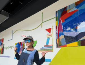 Artist Monica Bravo stands in front of a work of art she created