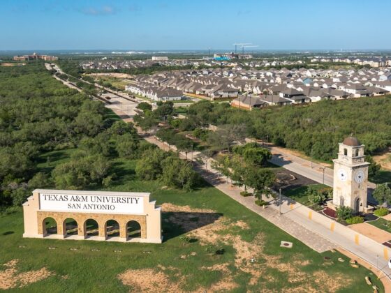 Entryway to Texas A&M - San Antonio on University Way with the VIDA San Antonio community on the right, from an aerial view on a bright sunny day