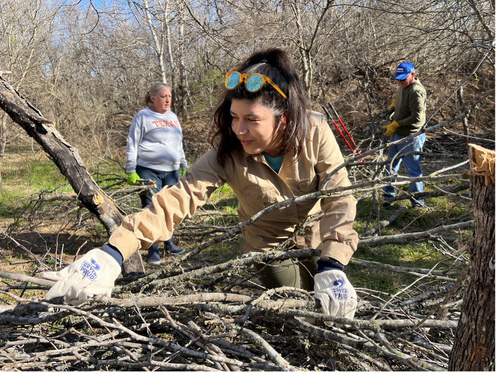 A volunteer picks up brush