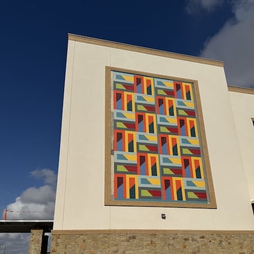 Colorful, geometric mural on the side of a newly built healthcare facility
