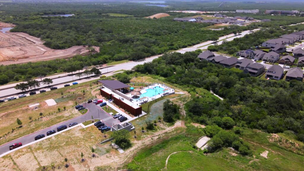 Aerial view of VIDA Pool & Clubhouse showing a modern building, pool, and parking lot