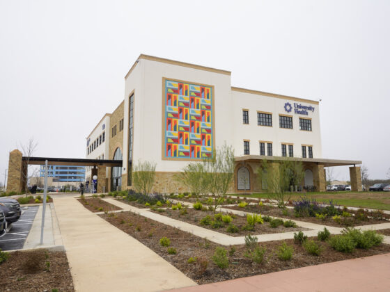 University Health Vida clinic building exterior showing a large white building with a large, colorful mural on the side of the building
