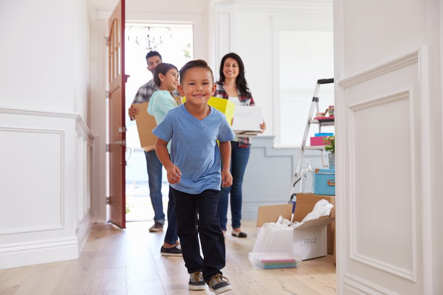 Portrait Of Hispanic Family Moving Into New Home